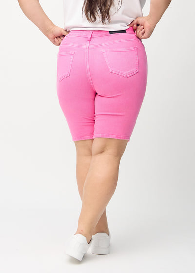 Lyserøde skinny middle shorts set bagfra på en plus-size model, så man kan se hele produktet.