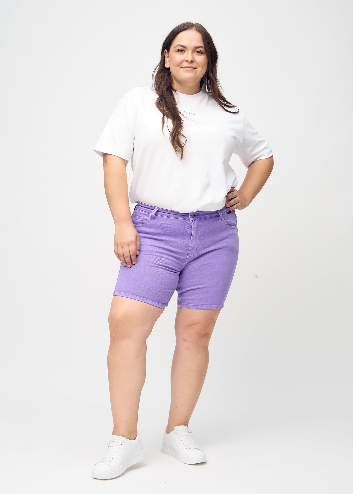 Fuldt billede af en plus-size model i lilla skinny short shorts.