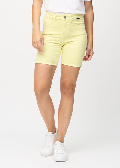 Lysegule skinny short shorts, modelnavn Lemonades, som sidder tæt til, og slutter midt på låret, set forfra.