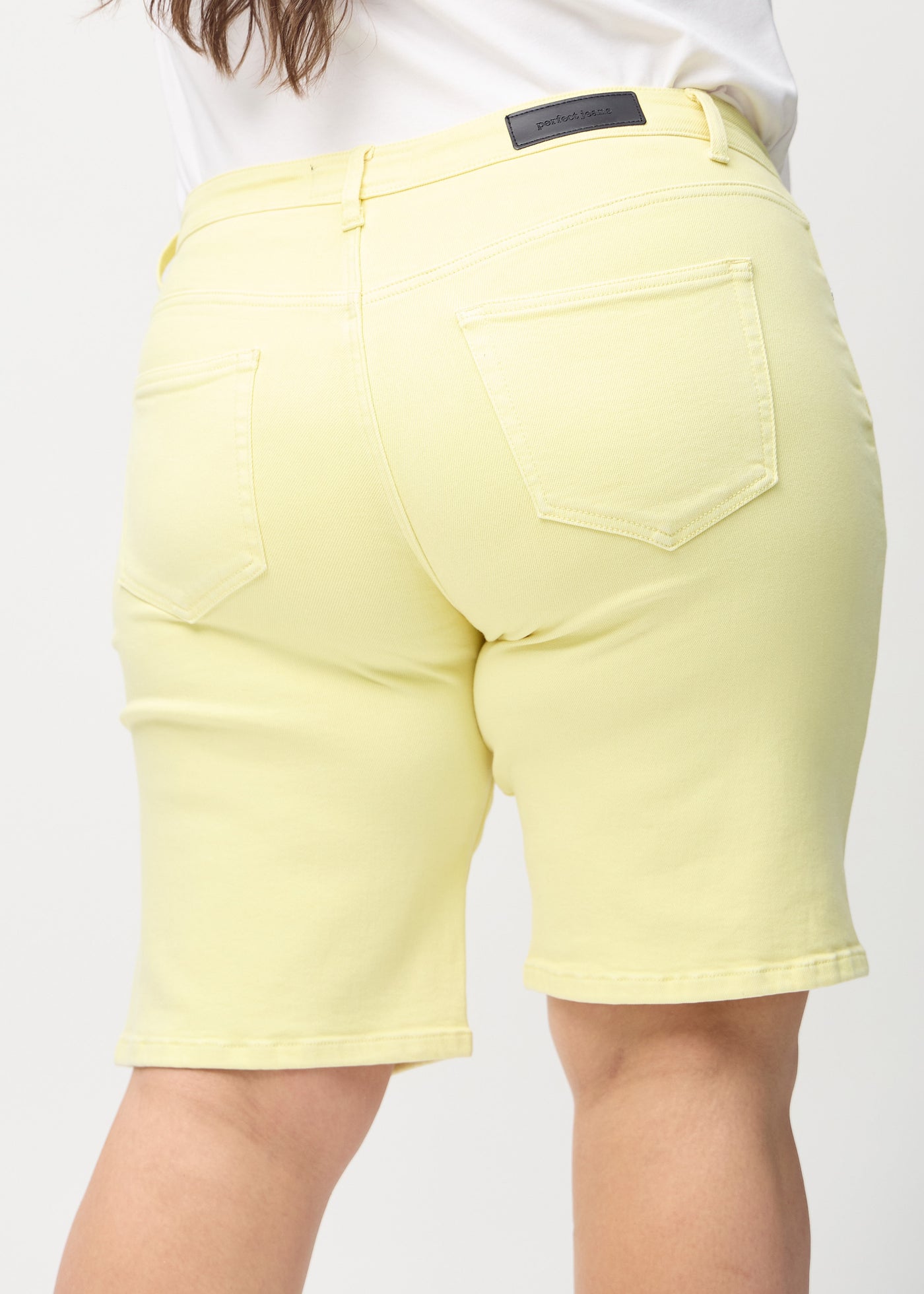 Lysegule regular middle shorts set bagfra tæt på en plus-size model for at vise detaljer.