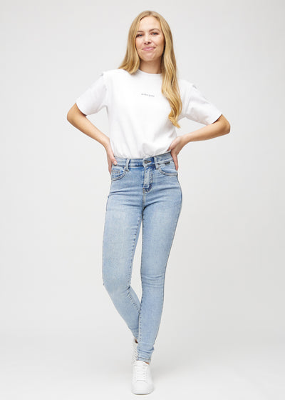 Fuldt billede af model i lys denim skinny jeans.