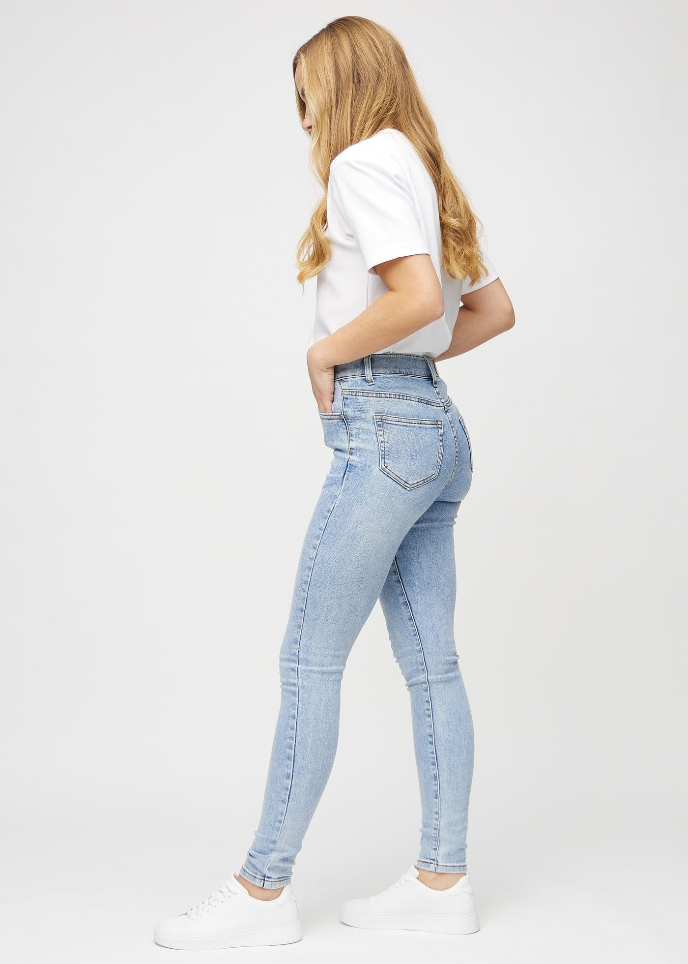 Lys denim skinny jeans set fra siden på model.