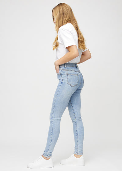 Lys denim skinny jeans set fra siden på model.