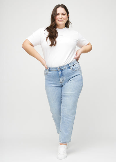 Fuldt billede af en plus-size model i lys denim regular jeans.