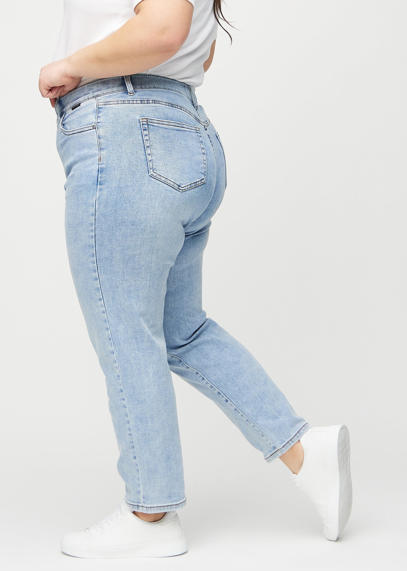 Lys denim regular jeans set fra siden på en plus-size model.