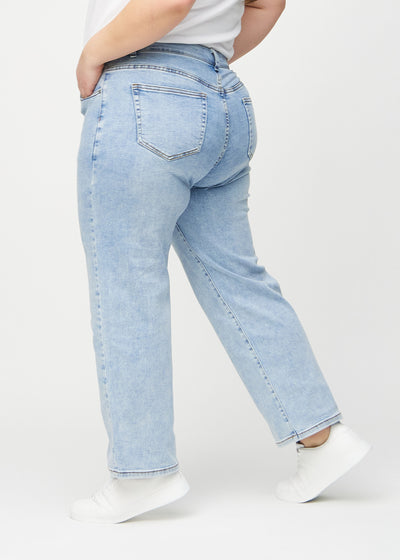 Lys denim loose jeans set fra siden på en plus-size model.