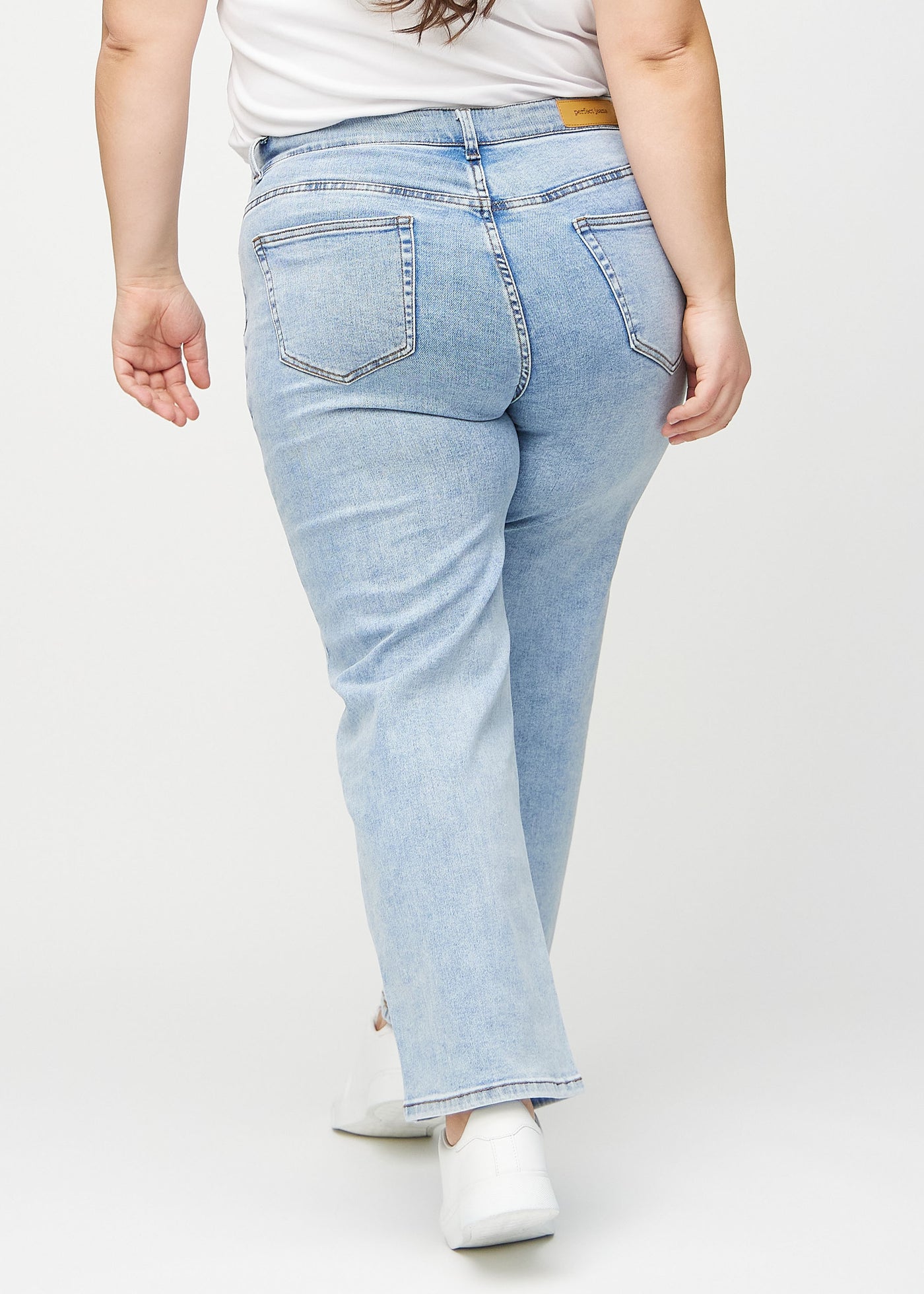 Lys denim loose jeans set bagfra på en plus-size model, så man kan se hele produktet.