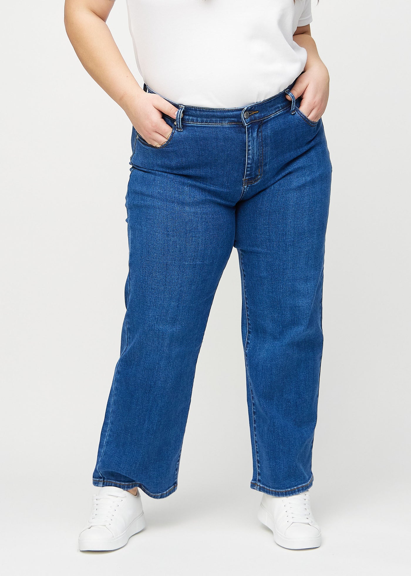 Mørk denim loose jeans, modelnavn Oceans, som er løstsiddende med masser af vidde i benene på en plus-size model, set forfra.