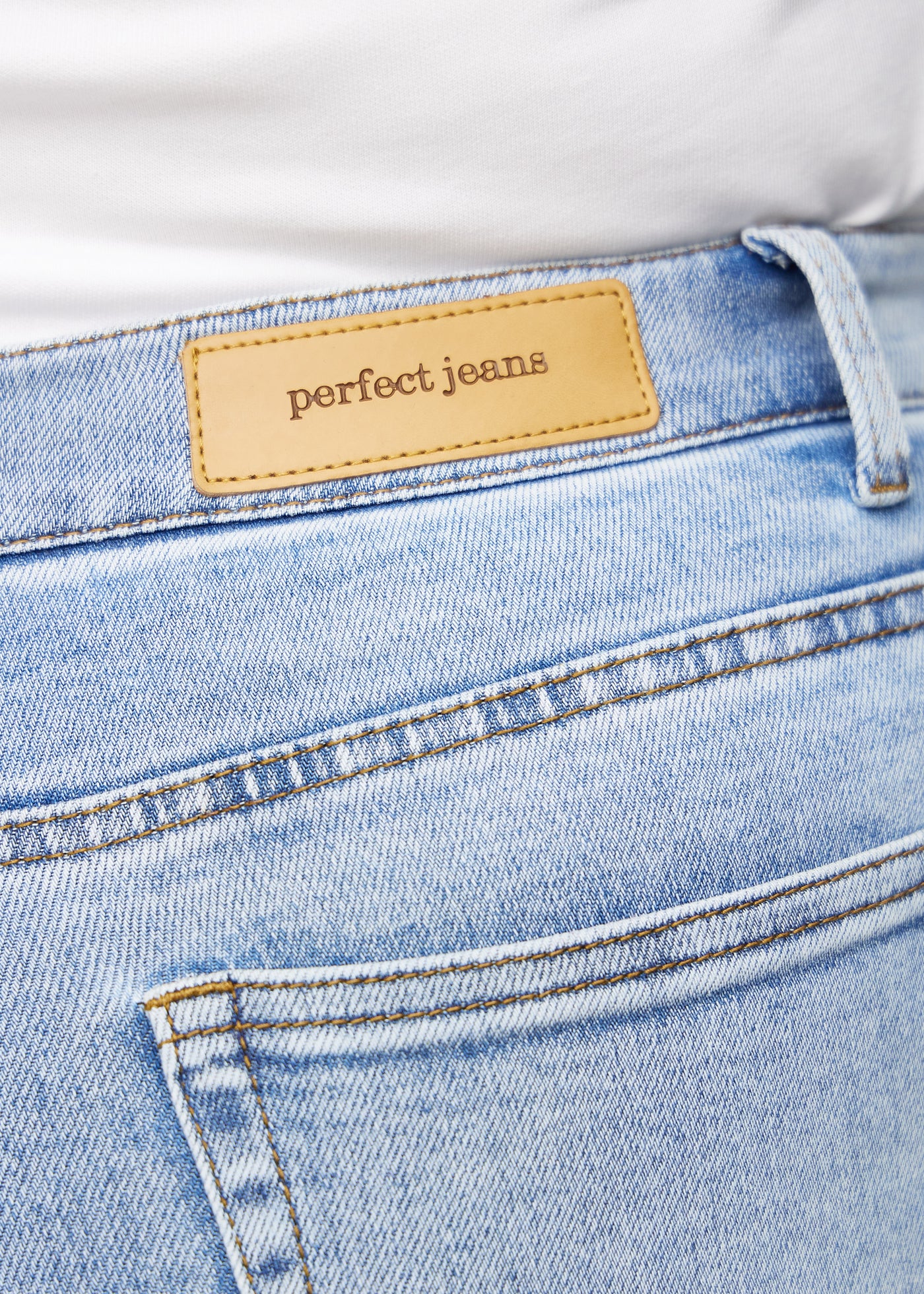 Baglommen på et par lys denim jeans, hvor man kan se logoet på en plus-size model.